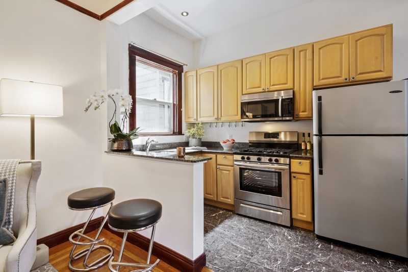 The 5-burner gas stove and microwave are new. There are granite counters and marble floors. Note the eat-in bar/perch.