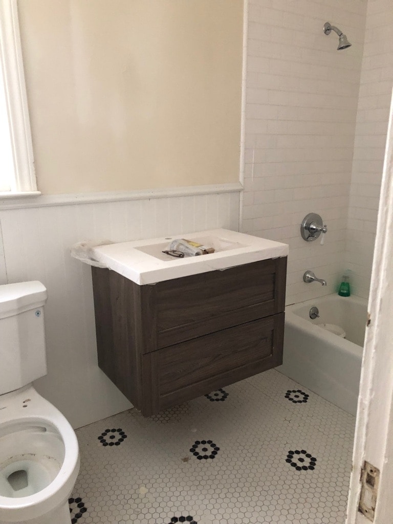 From a pedestal sink with a tiny medicine cabinet, to a floating vanity (with more storage than the old medicine cabinet) and room for a large, full-length mirror with an inset light fixture.