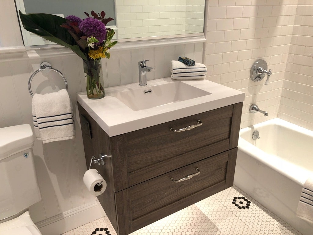 Replacing the pedestal sink with a floating vanity offered more storage and more lighting.