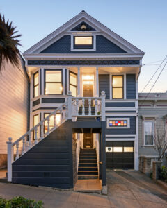 The front facade at 1882-1884 Church Street st twilight with lights on, an updated Victorian