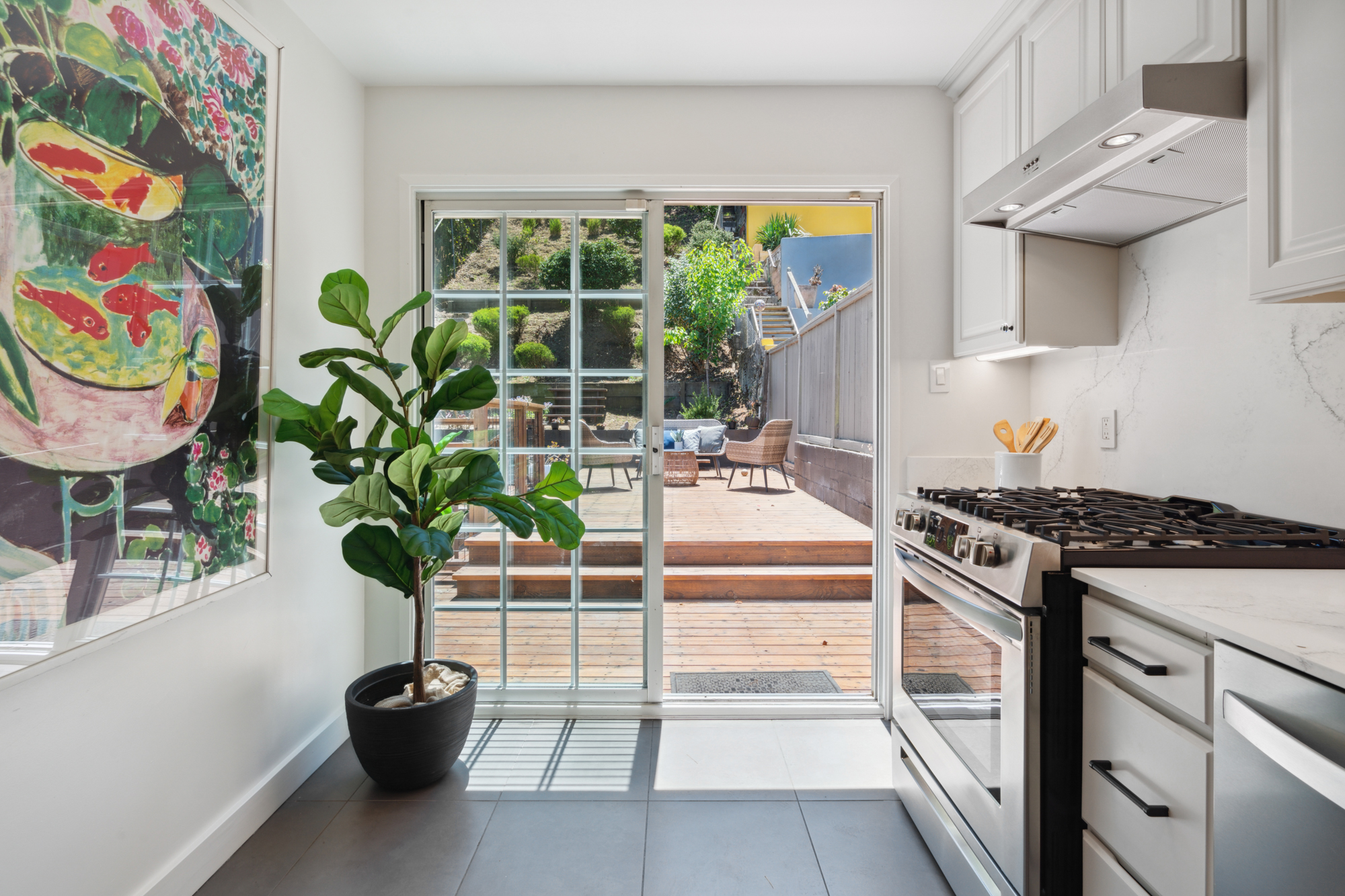 A lightly colored and updated kitchen with new quartz counters and backsplash