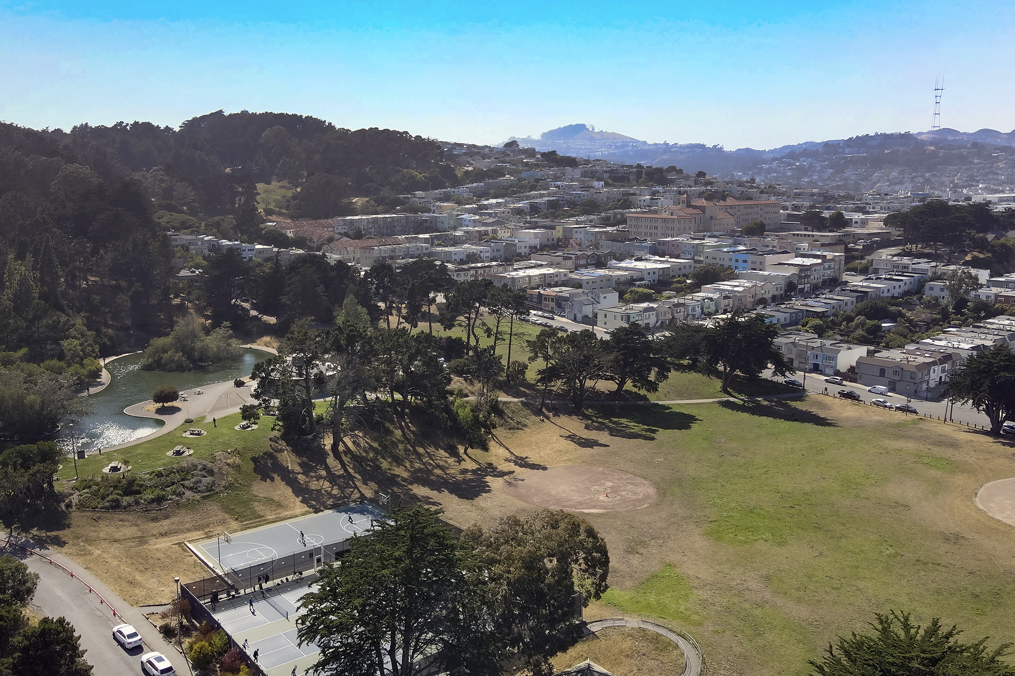 An aerial drone shot looking out over McLaren Park towards Twin Peaks