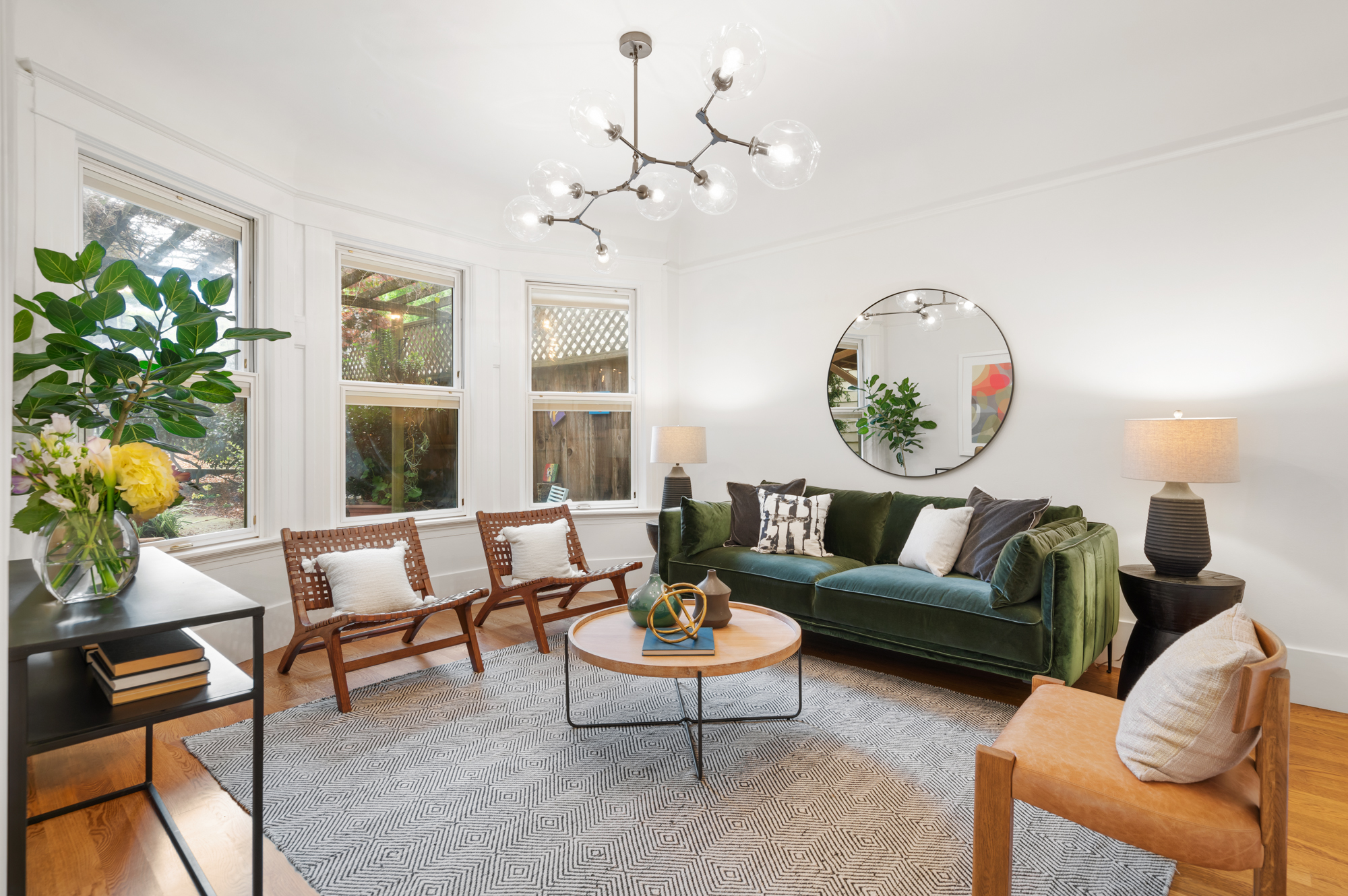 nviting living room with designer lighting, bay windows overlooking lush garden, and seamless access to stylish kitchen.