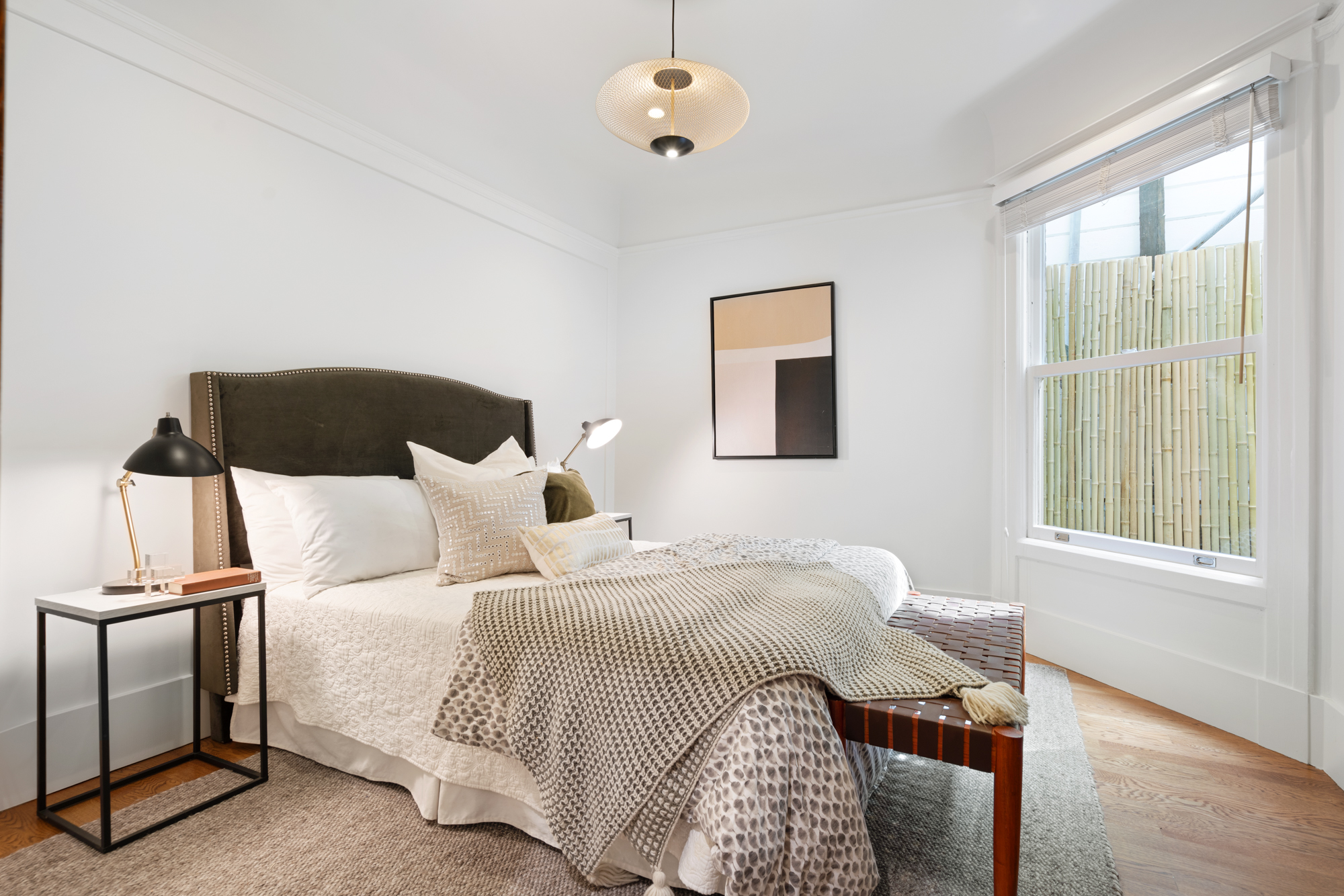Bright bedroom with hardwood floors, contemporary pendant lighting, frosted glass double doors.