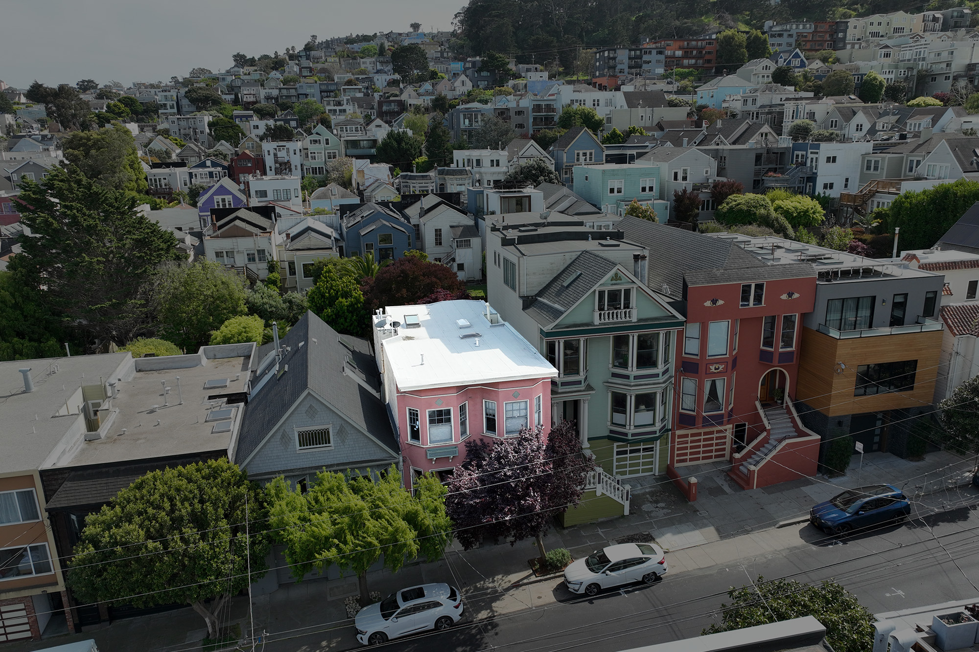 erial view highlighting 4255 24th Street, a stylish pink condominium located in the heart of Noe Valley, San Francisco, surrounded by charming homes